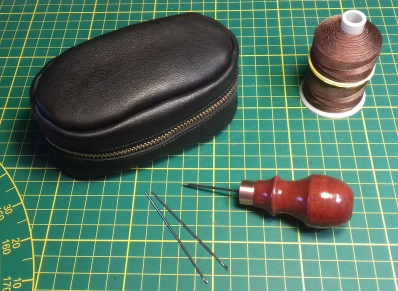 Sewing supplies, needles, thread and an awl Sewing supplies, needles, thread and an awl